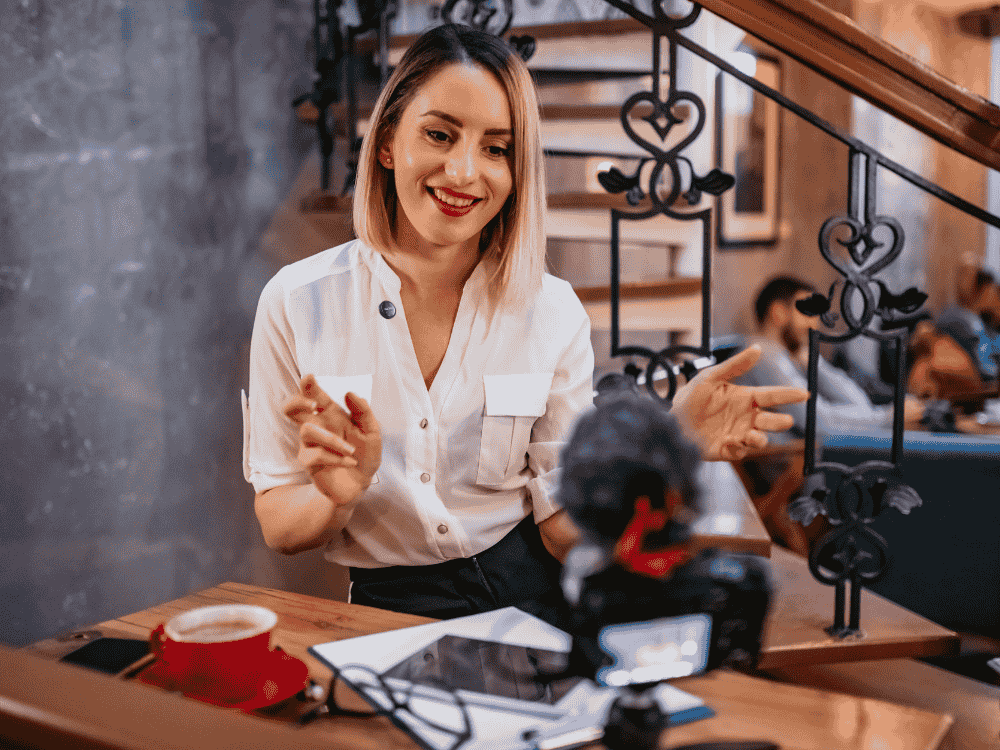 A woman vlogging her cafe business using a wireless microphone