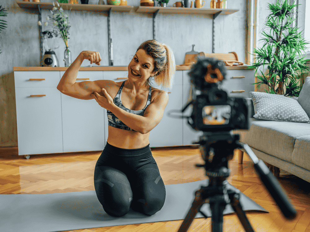 A woman recording a lecture for her online fitness class using a wireless microphone and camera