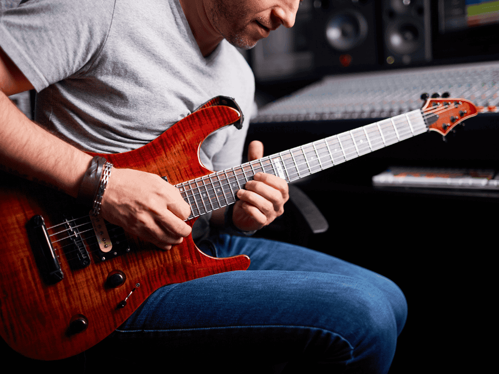 a male guitarist using the best usb audio interface for bass guitar