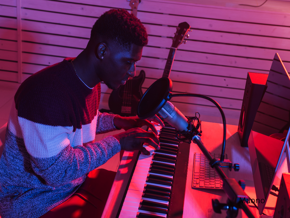 male recording music using piano keyboards and microphone