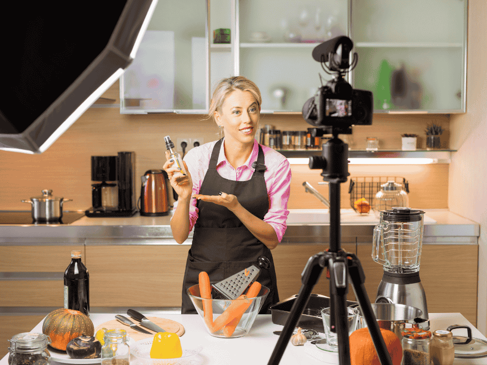 A woman recording a cooking vlog using a wireless microphone