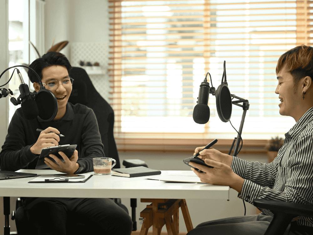 Two mal podcasters using a podcast microphone