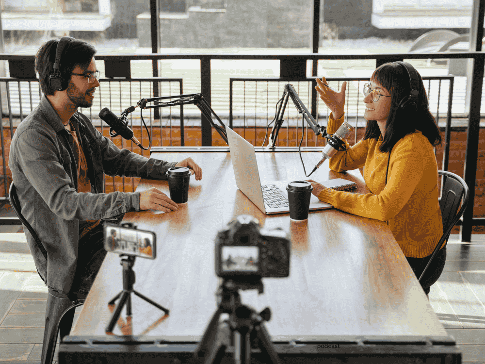  A male and female podcaster showing 2 person podcast microphone setup