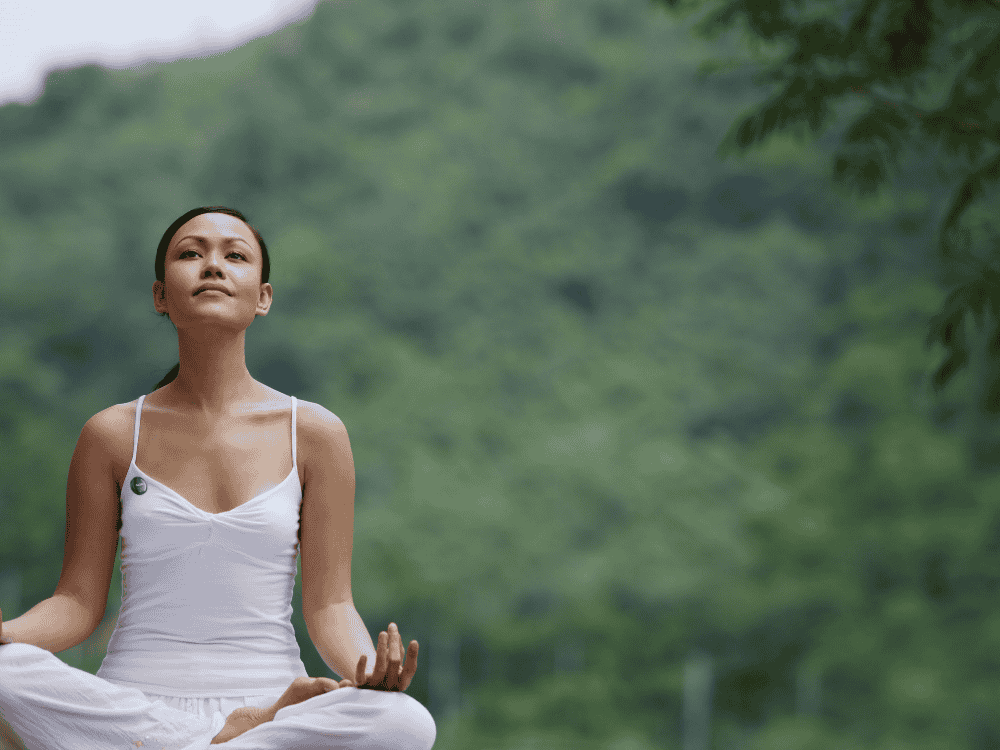 A woman meditating and vlogging in the morning using a wireless microphone