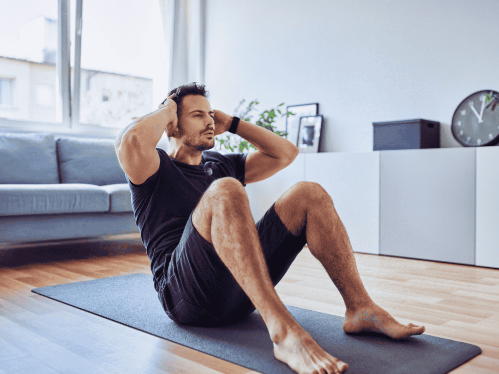 A man doing situps at home & vlogging it with a wireless microphone