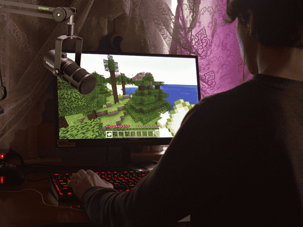 a male content creator live streaming Minecraft using a streaming microphone