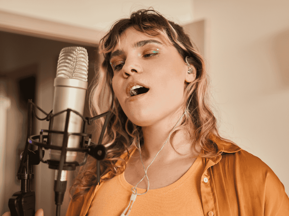 A woman at home studio recording using a microphone for singing