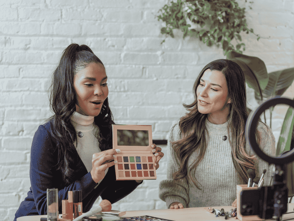 2 ladies promoting makeup brand using a wireless microphone for vlogging