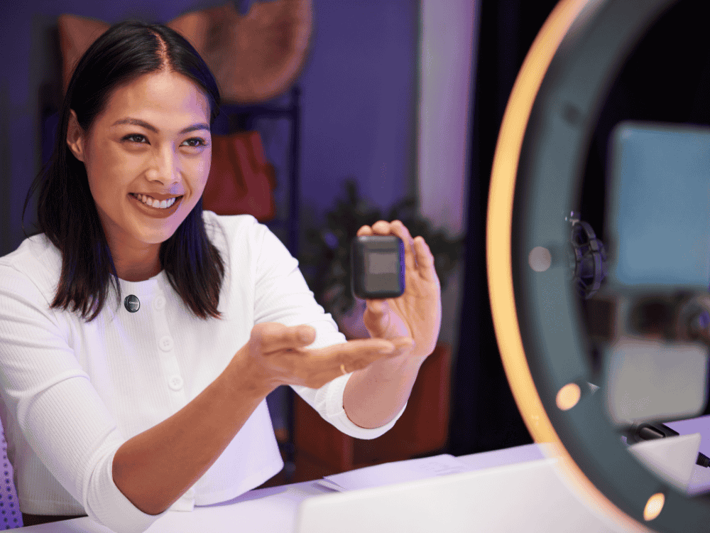 A woman reviewing a tech gadget using a Maono Wave T5 wireless microphone