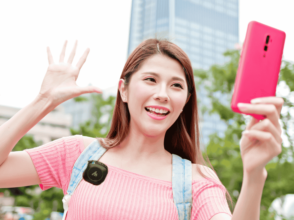 female livestreaming on TikTok using a smartphone and a wireless microphone